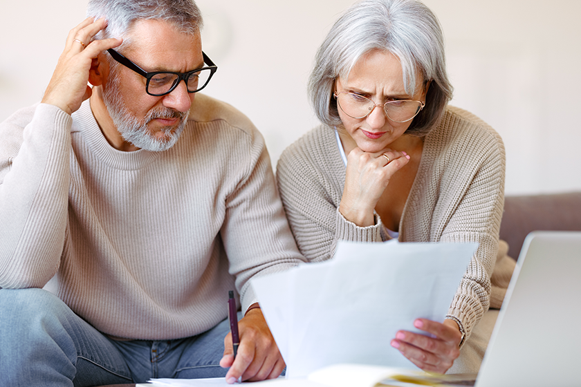 Worried senior family reading financial documents or notification letter with bad news from bank 